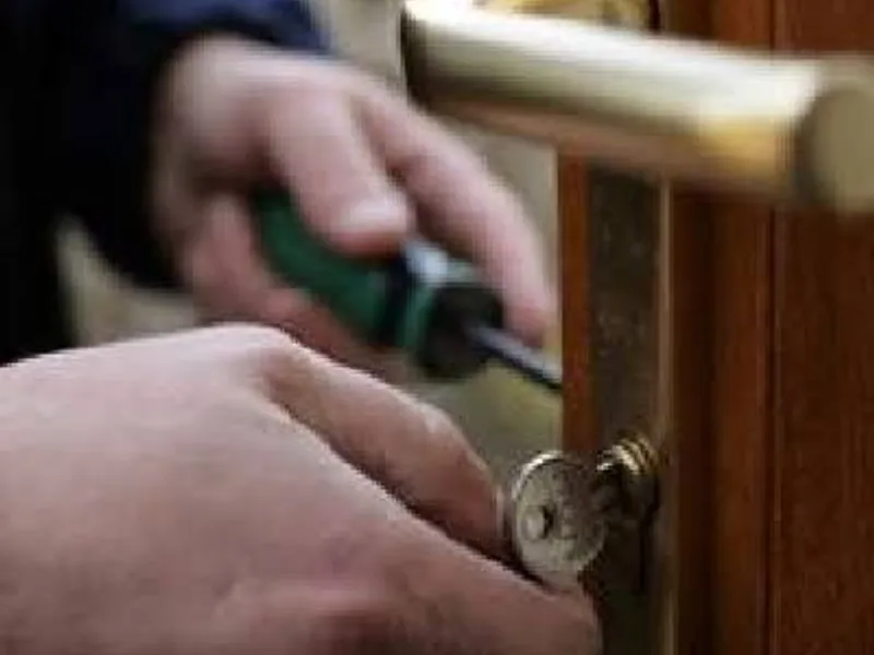 Cerrajero abriendo una puerta de madera con la llave en el cilindro